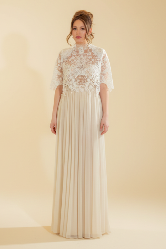 Woman wearing a lace dress standing in front of a mirror.