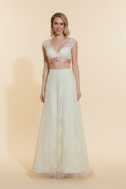 Woman in a white lace dress standing in an elegant room with red walls and wooden floor.