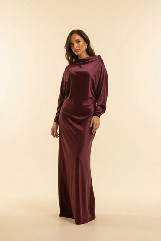 Woman wearing a burgundy dress against a beige background