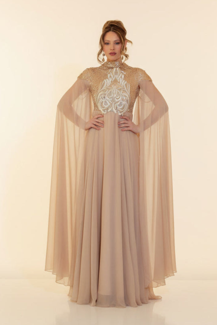 Woman wearing a long, elegant dress with a cape on a plain background