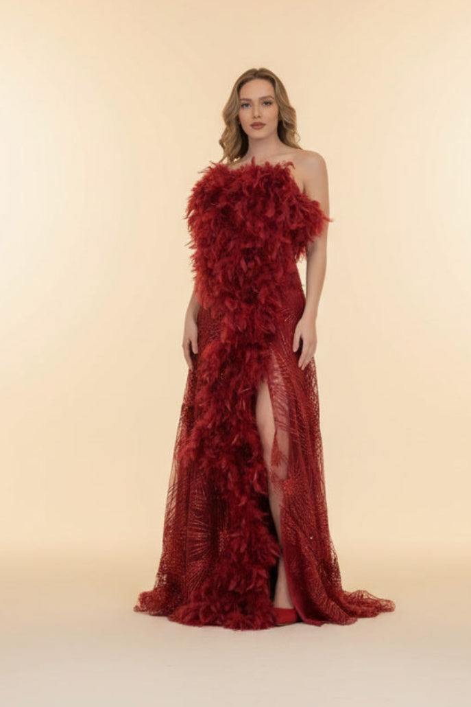 Woman wearing a red floral evening gown against a beige background