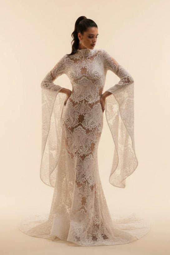 Woman wearing a elegant white lace dress against a beige background